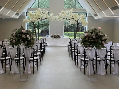 Wedding Aisle Styling – A breathtaking ceremony setting featuring blossom trees and beautiful floral displays for a truly memorable entrance.