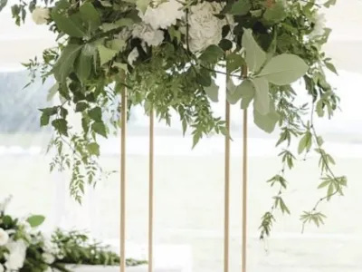 Gold Floral Display Stand – An elegant gold stand adorned with flowing greenery and flowers, perfect for sophisticated wedding centrepieces.